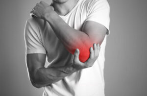 A man holding hands. Pain in the elbow. The hearth is highlighted in red. Close up. Isolated background.
